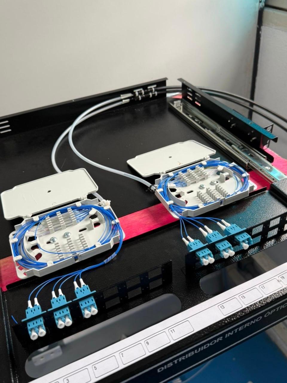 Caixas de emenda e distribuição de fibra óptica abertas mostrando os filamentos